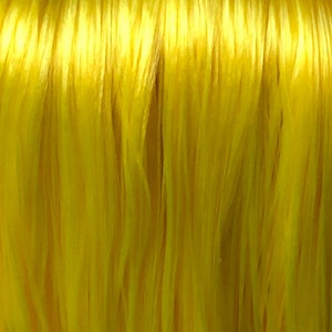 May include: Close-up of a bright yellow fiber, resembling a bundle of thin threads.