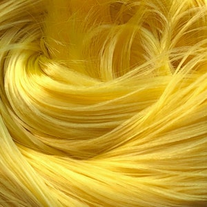 May include: Close-up of a bundle of bright yellow yarn. The yarn is soft and fluffy, and the strands are tightly woven together.
