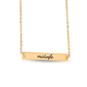 May include: A gold-toned necklace featuring a horizontal rectangular bar pendant. The word midwife is engraved in a black cursive script across the center of the bar. The pendant is suspended from a delicate gold-toned chain link necklace.