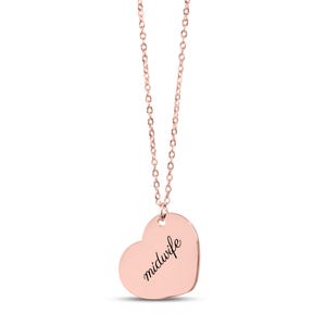 May include: A rose gold-toned heart-shaped pendant necklace featuring a delicate chain and a smooth, polished surface. The word midwife is engraved in a black, elegant cursive script across the center of the heart-shaped charm.