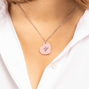 May include: A silver-toned chain necklace featuring a heart-shaped pendant with a light pink finish. The pendant is engraved with the black text "BIG sister" in a clean, sans-serif font, centered on the smooth surface of the heart.