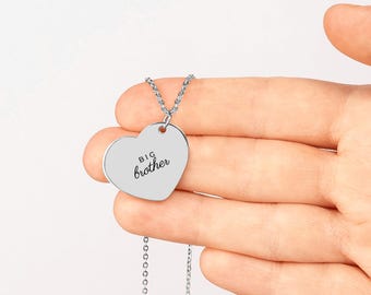 May include: A silver-toned heart-shaped pendant necklace featuring the engraved text "BIG brother" in a black sans-serif and script font. The pendant hangs from a delicate matching silver-toned metal chain link necklace.