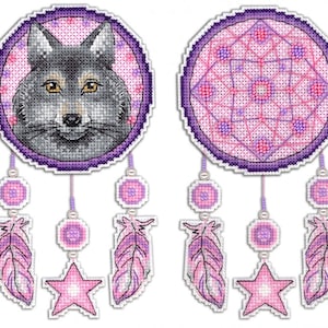 Peut inclure: Deux attrape-rêves violets et roses avec des plumes blanches et des étoiles qui pendent. Un attrape-rêves représente un visage de loup et l'autre un motif géométrique.
