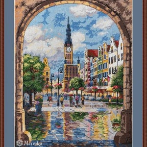 Könnte beinhalten: Ein farbenfrohes Kreuzstichmuster, das einen Blick auf eine europäische Stadtstraße durch einen Torbogen zeigt. Die Straße ist von Gebäuden gesäumt, und es sind Menschen auf der Kopfsteinpflasterstraße unterwegs. Der Himmel ist blau mit weißen Wolken. Die Gebäude sind eine Mischung aus Rot, Gelb und Grün.