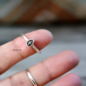 Può includere: Un anello d'argento con un piccolo design a forma di lacrima che presenta una stella al centro.