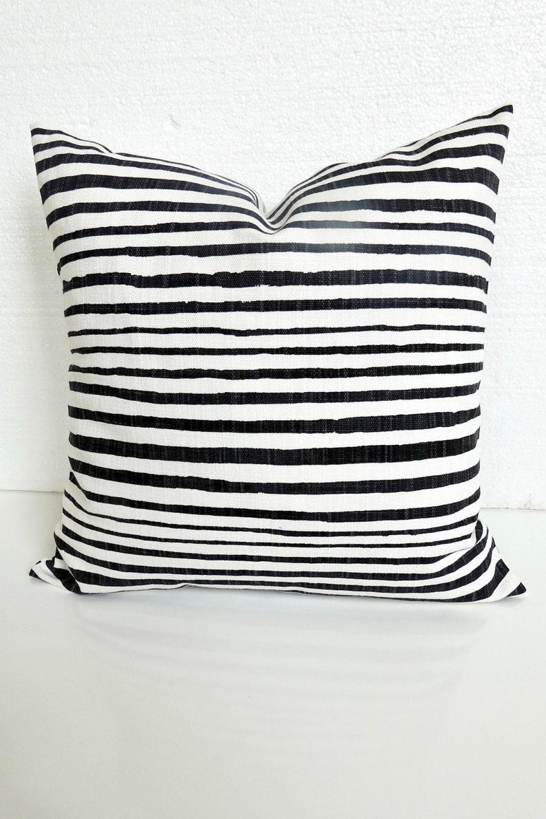 K&ouml;nnte beinhalten: Schwarzes und wei&szlig;es gestreiftes Kissen mit schlichtem, modernem Design.