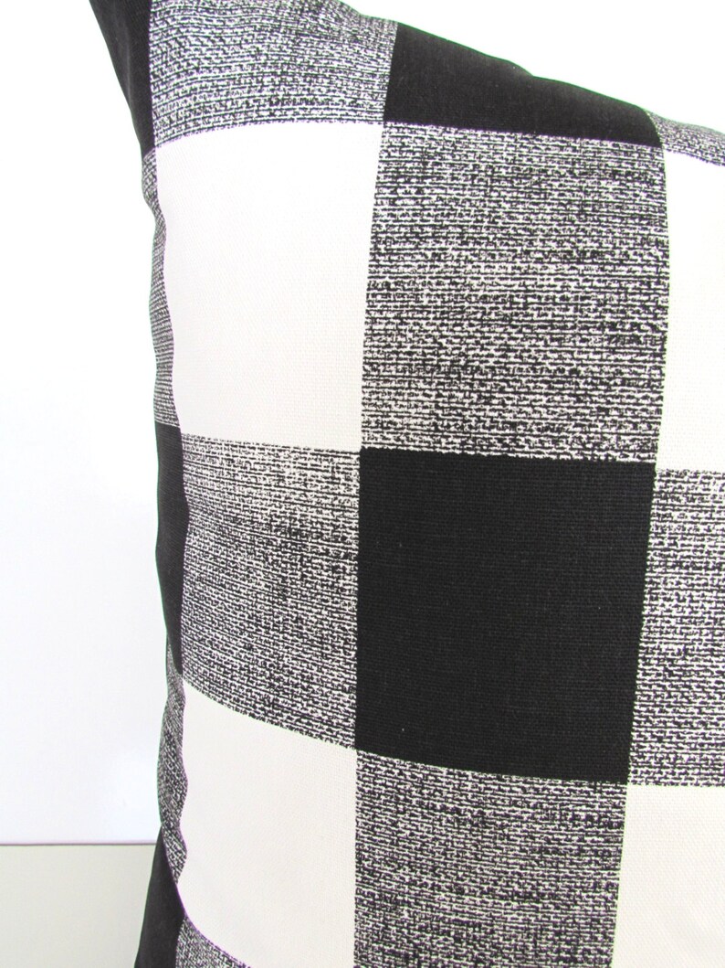 May include: Black and white checkered throw pillow with a subtle textured fabric.