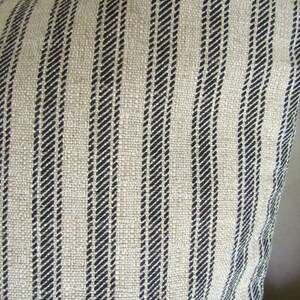 K&ouml;nnte beinhalten: Nahaufnahme eines beige-schwarz gestreiften Stoffes. Der Stoff hat eine gewebte Textur und besteht aus Naturfasern.
