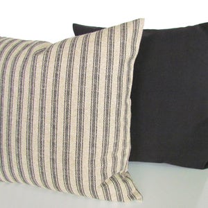 May include: Two decorative throw pillows, one with black and white stripes and one solid black. The striped pillow is made of a textured fabric.