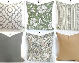 May include: Six different pillow covers with various patterns and colors. The pillows are arranged in two rows of three. The top row features a geometric pattern in gray and white, a floral pattern in green and white, and a striped pattern in green and white. The bottom row features a solid gray pillow, a patterned pillow in green, brown, and white, and a solid tan pillow.
