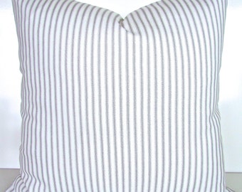 May include: A white pillow with thin gray stripes. The pillow is made of a soft, woven fabric.