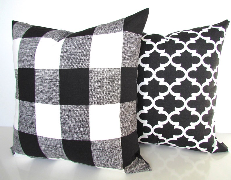 May include: Two decorative throw pillows, one with a black and white buffalo check pattern and the other with a black and white geometric pattern.