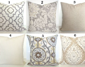 May include: Six decorative throw pillows with various patterns. Pillows include geometric, floral, striped, and medallion designs in neutral colors like gray, beige, and cream. The pillows are square-shaped and appear to be made of fabric.