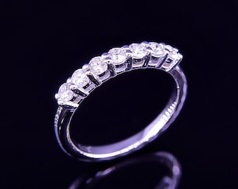 May include: A silver band with a row of clear round diamonds set in a half-circle shape.
