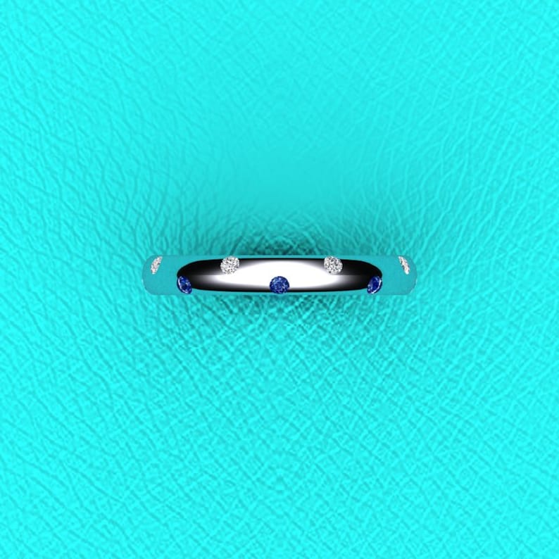 May include: A silver band ring with alternating blue and white gemstones.