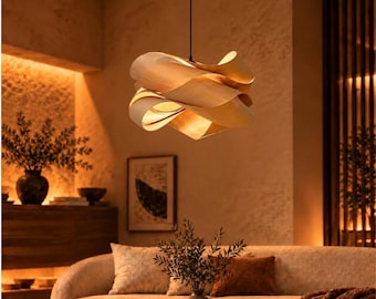 May include: A pendant light fixture featuring a series of light-colored, curved wooden slats arranged in a layered, swirling shape. The fixture is suspended from a black circular ceiling mount by a thin black cord, emitting a warm glow.