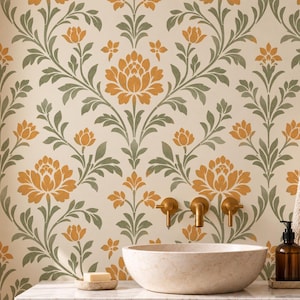 Könnte beinhalten: Ein Wand-Schablonenmuster mit sich wiederholenden orangefarbenen Blumenmotiven und salbeigrünen Blattreben auf cremefarbenem Hintergrund. Das Design ist an einer Badezimmerwand über einem Holzwaschtisch mit Steinbecken und Messingarmaturen zu sehen.