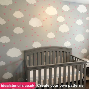 May include: A nursery room with a grey cot and a grey rocking chair. The wall is painted grey and decorated with white clouds and pink hearts.
