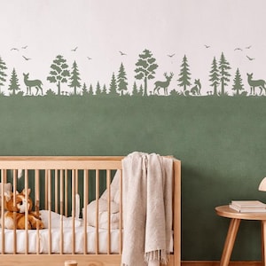 Peut inclure: Une chambre d'enfant avec un lit bébé en bois, un tableau encadré de renard et une fresque murale sur le thème de la forêt. La pièce comprend un ours en peluche, un cheval à bascule et un panier en osier. La palette de couleurs est neutre avec des tons verts et bois.