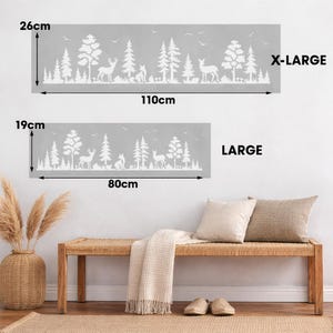 May include: Two gray wall decals with a white forest scene featuring trees, deer, and foxes. The larger decal is 43 inches wide and 10 inches tall, and the smaller one is 31 inches wide and 7.5 inches tall. Text on the image reads "X-LARGE" and "LARGE".