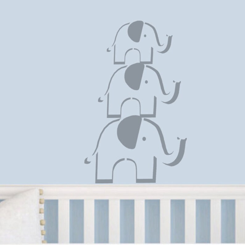 May include: Three gray elephant silhouettes stacked on top of each other on a light blue wall. The elephants are facing right and have their trunks raised.