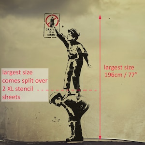 Puede incluir: Arte de est&eacute;ncil en blanco y negro de dos ni&ntilde;os, uno de pie sobre los hombros del otro, sosteniendo una lata de aerosol. El letrero que est&aacute; encima de ellos dice "Graffiti is a crime". El est&eacute;ncil mide 196 cm de alto y viene en dos hojas XL.