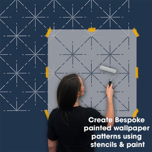 May include: A woman uses a paint roller to apply paint through a stencil, creating a geometric pattern on a wall. The stencil is taped to the wall. Text reads: Create Bespoke painted wallpaper patterns using stencils & paint.