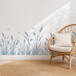 May include: A wall decal featuring a repeating pattern of blue wheat stalks and small flying birds. The design is applied horizontally along the lower portion of a white wall, creating a continuous botanical border across the surface.