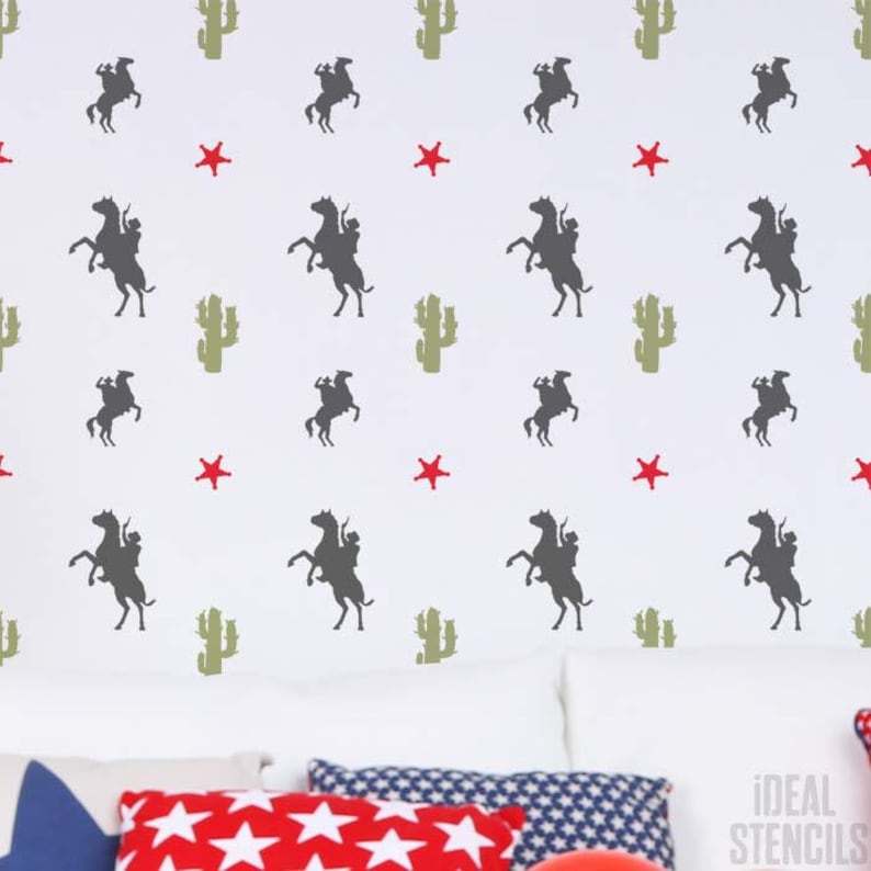 May include: A white wall with a repeating pattern of cowboys riding horses, cacti, and red stars. The pattern is a stencil design.