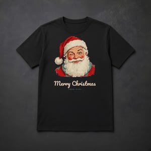 May include: A black short-sleeve t-shirt featuring a graphic of a winking Santa Claus wearing a red hat with white trim. Below the illustration, the text reads Merry Christmas in a cream-colored font, followed by smaller text that reads NORTH POLE EST. 1823.