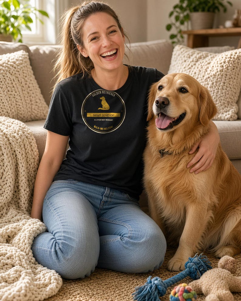 K&ouml;nnte beinhalten: Ein schwarzes T-Shirt mit einer kreisf&ouml;rmigen goldenen Grafik, die die Silhouette eines Hundes und den Text zeigt: GOLDEN RETRIEVER THERAPY DEPARTMENT NO APPOINTMENT NECESSARY WALK-INS WELCOME. Das T-Shirt wird mit einer hellblauen Jeans kombiniert.