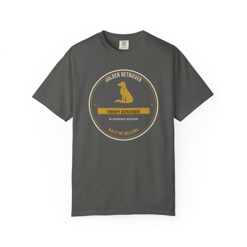K&ouml;nnte beinhalten: Ein anthrazitfarbenes Kurzarm-T-Shirt mit einer kreisf&ouml;rmigen Grafik, die die Silhouette eines Golden Retrievers zeigt. Der Text lautet: GOLDEN RETRIEVER, THERAPY DEPARTMENT, NO APPOINTMENT NECESSARY und WALK-INS WELCOME in Beige und Wei&szlig;.