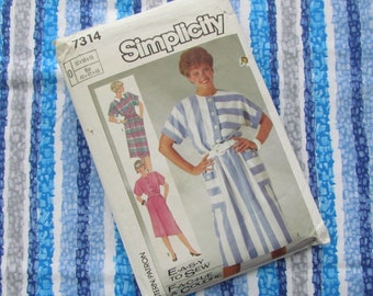 May include: Simplicity sewing pattern 7314 featuring three dress designs. The main dress is a button-down style with blue and white stripes. The pattern includes the text "E-A-S-Y TO SEW". The background is a blue and white striped fabric.