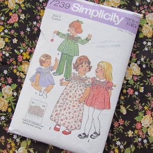 May include: Simplicity sewing pattern for a size 3 toddler. The pattern features illustrations of children's clothing, including dresses and a top with pants. The pattern envelope is white with the Simplicity logo and product details.