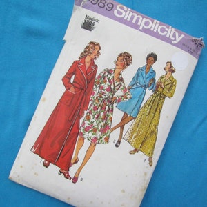 May include: A vintage Simplicity sewing pattern for a robe, featuring four women wearing different styles of robes. The pattern number is 9889 and the size is Medium. The pattern is printed on white paper with a purple and white border.