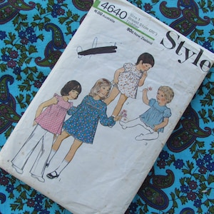 May include: A vintage sewing pattern for children's dresses. The pattern is for size 1, with a 51 cm (20 inches) chest. The pattern is called "Style" and has a number of 4640. The pattern shows four girls wearing different dresses.