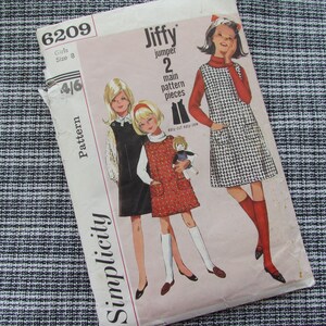 May include: Simplicity pattern number 6209 for a girls' Jiffy jumper. The pattern is for sizes 4 to 6 and includes two main pattern pieces. The pattern cover features three girls wearing the jumper in different colors and patterns.
