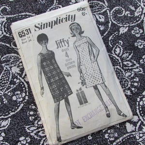 May include: A vintage Simplicity 6531 sewing pattern envelope for a Jiffy dress, size 14, bust 34. The white paper envelope features black line illustrations of two sleeveless dresses, one with a grid pattern and one with a star print.