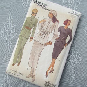 Puede incluir: Patrón de costura Vogue Patterns número 8764 para las tallas 12-14-16. El patrón presenta tres atuendos para mujeres: un traje de pantalón verde, un traje de falda blanco y un traje de falda negro.