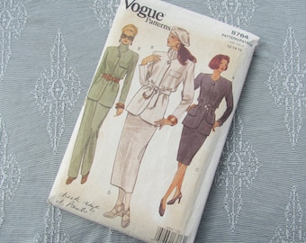May include: Vogue Patterns sewing pattern number 8764 for sizes 12-14-16. The pattern features three women's outfits: a green pantsuit, a white skirt suit, and a black skirt suit.