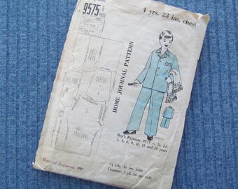 May include: A vintage sewing pattern for a boy's pajamas, pattern number 9575. The pattern is for sizes 2-14 years and includes instructions for making the pajamas. The pattern is printed on a white background with black text and illustrations.