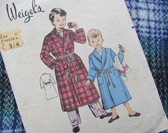 May include: Vintage sewing pattern for boys' robes. The pattern is for sizes 3/4. The pattern shows two boys wearing robes, one in red plaid and one in blue. The pattern is from Weigel's.