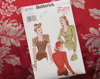 May include: A vintage Butterick sewing pattern, number 6701, featuring retro fashion illustrations. The pattern includes designs for a jacket and other garments. The pattern is set against a red floral fabric background.