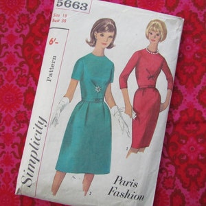 Puede incluir: Patrón de costura vintage Simplicity número 5663 para un vestido. El patrón es para la talla 18, busto 38. El patrón presenta a dos mujeres con vestidos, una en turquesa y otra en rojo. El patrón se titula "Paris Fashion".