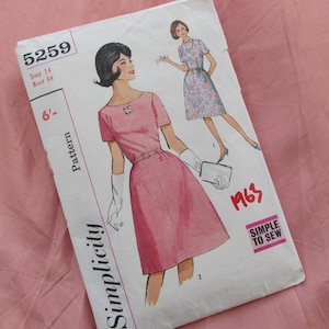 May include: Vintage Simplicity sewing pattern number 5259 for a dress. The pattern is for size 14, bust 34 inches. The pattern shows a pink dress with short sleeves and a white belt. The pattern is from 1963 and is labelled "Simple to Sew".