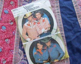 May include: Vogue Patterns sewing pattern envelope featuring two couples in Western-style shirts. The shirts are light pink and denim blue, with floral embroidery. The envelope is on a patterned fabric background.