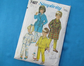 May include: Simplicity sewing pattern number 7407 for children's robes. The pattern includes four different robe designs: a blue robe with a white collar, a plaid robe, a yellow robe, and a floral robe. The pattern is for sizes 3.