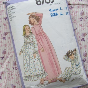 May include: A sewing pattern for two sizes of nightgowns and pajamas. The pattern includes instructions for making a long-sleeved nightgown with a floral print, a long-sleeved nightgown with a solid pink color, and pajamas with a floral print. The pattern also includes measurements for the sleeves and pants.