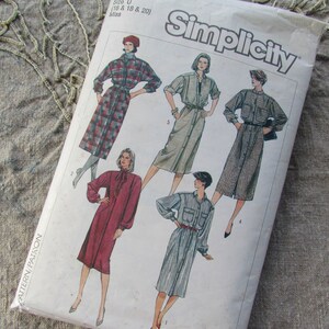 May include: Simplicity sewing pattern envelope showing illustrations of button-down dresses. The dresses are in various colours and patterns, including plaid and solid hues. The envelope is labelled "Simplicity" in a bold font.