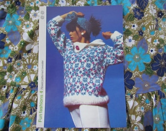 May include: A vintage magazine page featuring a woman wearing a flower-patterned sweater. The sweater has a white collar and cuffs, with a blue and pink floral design on a white background. The text "Fun fashions 4 Flower patterned sweater" is visible.
